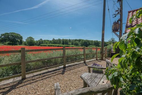 a wooden bench in front of a field of flowers at Little House, Aldringham in Leiston