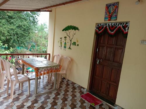 uma sala de jantar com uma mesa e cadeiras e uma porta em Gharat Cottage em Alibaug