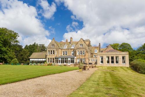 a large house with a large grassy yard at Grinkle Park Hotel in Loftus