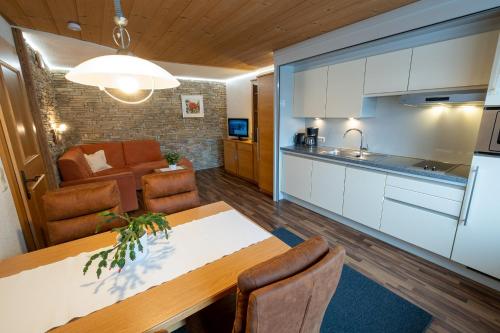 cocina y sala de estar con mesa y sillas en Gästehaus Haag en Ehrwald