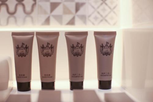 a group of three bottles of sunscreen on a shelf at Stanton City Hotel in Kota Kinabalu