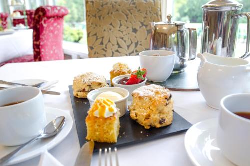 a table with a tray of muffins and cups of coffee at Grinkle Park Hotel in Loftus