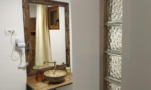 a bathroom with a sink and a mirror at Camere de inchiriat La Locanda in Dubova
