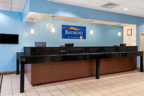 a desk in a room with a sign on the wall at Baymont by Wyndham Queensbury/Lake George in Queensbury