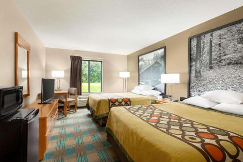 a hotel room with two beds and a flat screen tv at Super 8 by Wyndham Hannibal in Hannibal