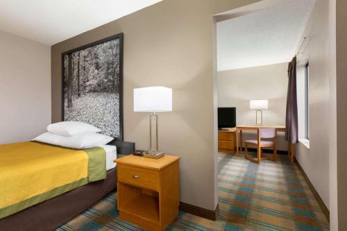 a hotel room with a bed and a desk at Super 8 by Wyndham Hannibal in Hannibal