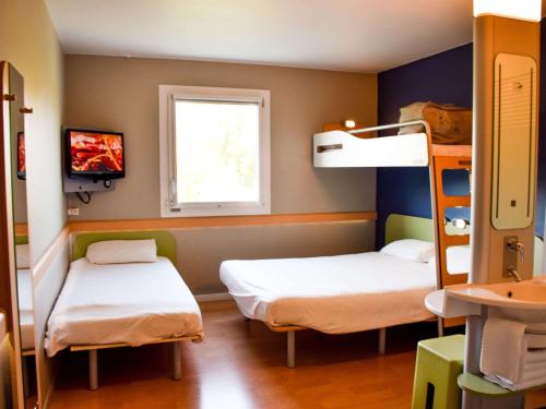 ロデーズにあるibis budget Rodezの二段ベッド2台と窓が備わる客室です。