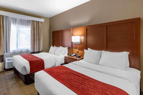 a hotel room with two beds and a window at Comfort Suites Fort Collins Near University in Fort Collins