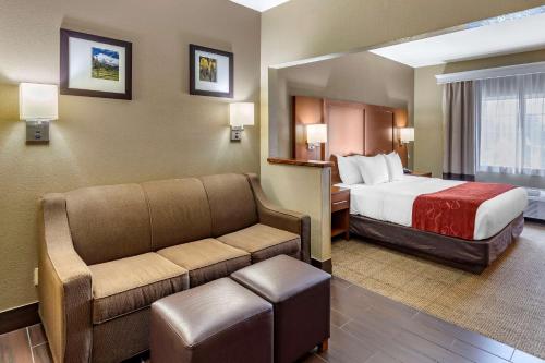 a hotel room with a bed and a couch at Comfort Suites Fort Collins Near University in Fort Collins
