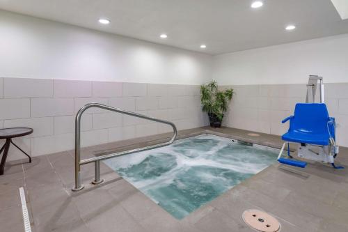 a hot tub in a room with a blue chair at Comfort Suites Fort Collins Near University in Fort Collins