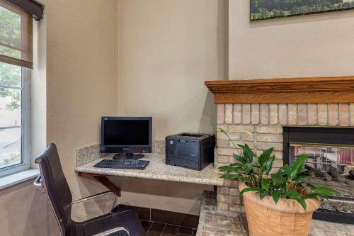 a computer sitting on a desk next to a fireplace at Comfort Suites Fort Collins Near University in Fort Collins
