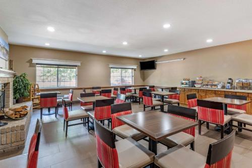 a restaurant with tables and chairs and a fireplace at Comfort Suites Fort Collins Near University in Fort Collins