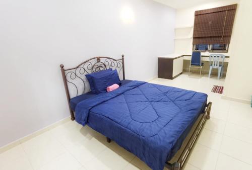 a bedroom with a bed with a blue comforter at Happy Journey Homestay Mersing in Mersing
