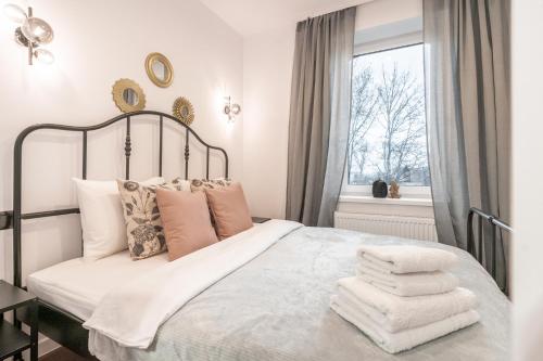sypialnia z łóżkiem z białą pościelą i poduszkami w obiekcie Apartament Królowa Luiza w Zabrzu