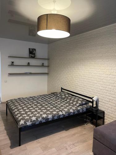 a bed in a room with a brick wall at 073 Уютная квартира ЖК «Софиевская Слободка» in Vyshneve