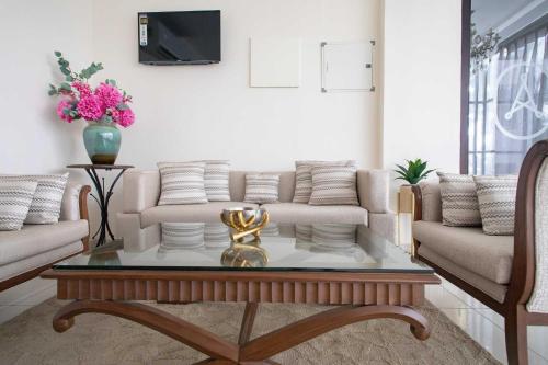 a living room with a couch and a table at Hotel Alaya in Dehradun