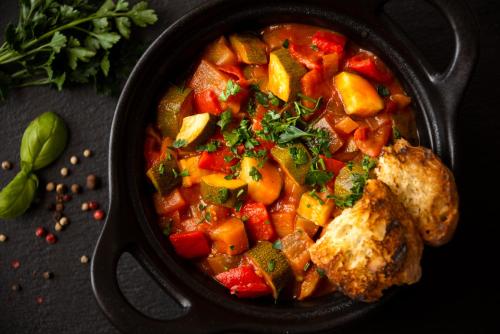 a pan filled with a stew of vegetables and meat at MarBella, Mar-Bella Collection in Agios Ioannis Peristeron