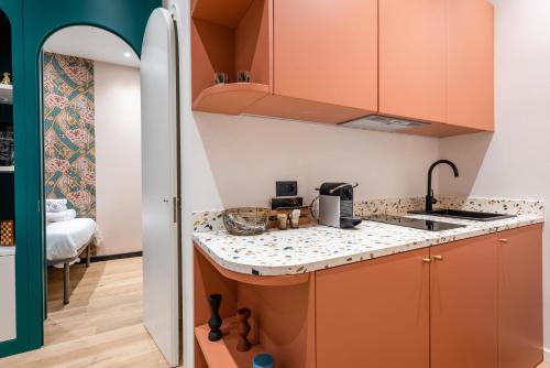 cocina con armarios de color naranja y encimera en Stylish and fancy flat close to Montenapoleone Brera by Easylife, en Milán