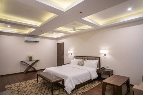 a bedroom with a white bed and a coffered ceiling at Hotel Alaya in Dehradun