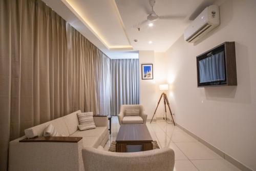a living room with a couch and a table at Hotel Alaya in Dehradun