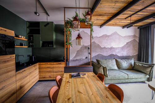 een woonkamer met een houten tafel en een bank bij Apartamenty Riders Lodge Szczyrk Olimpijska in Szczyrk