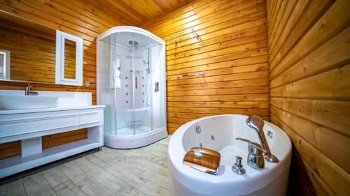uma casa de banho com uma banheira, um chuveiro e um lavatório. em Eco Villa Meryem em Kalkan