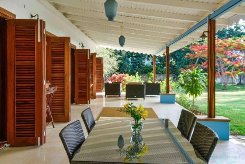 a dining room with a table and chairs and flowers at Tamarind Tree Zanzibar in Mazizini
