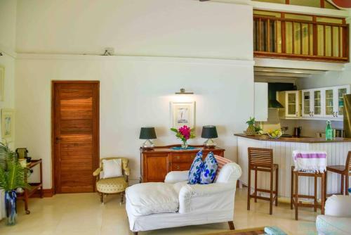 a living room with a white couch and chairs at Tamarind Tree Zanzibar in Mazizini