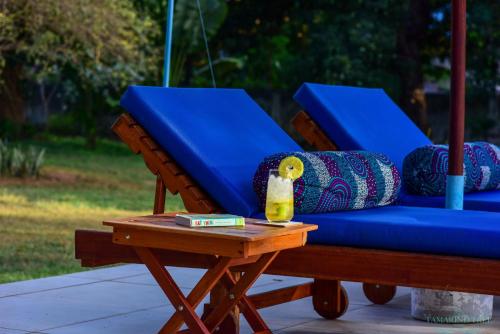 a blue couch on a table with a bottle on it at Tamarind Tree Zanzibar in Mazizini