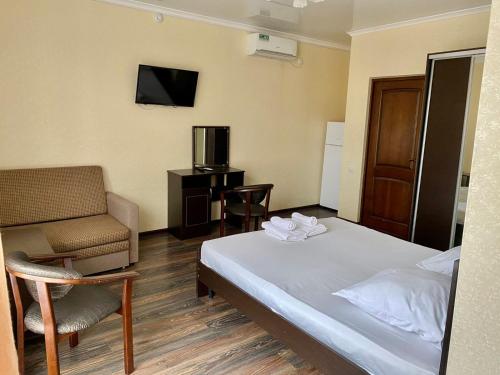 ジュブガにあるVelvet Seaのベッド、椅子、テレビが備わるホテルルームです。