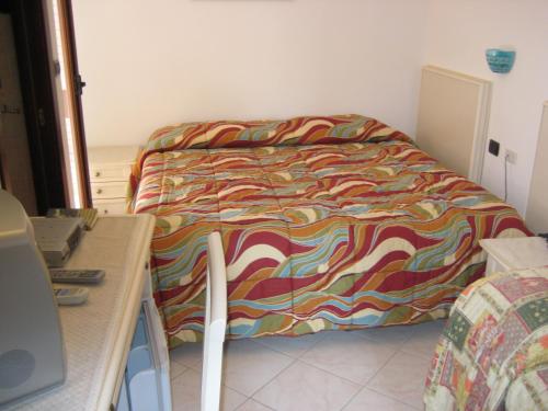 a bed with a colorful comforter in a room at Scano Comfort Inn in Santa Teresa Gallura