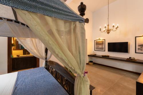 a bedroom with a bed and a tv in a room at Sundara by Mosvold in Balapitiya