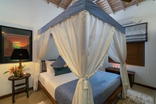 a bedroom with a canopy bed and a window at Sundara by Mosvold in Balapitiya