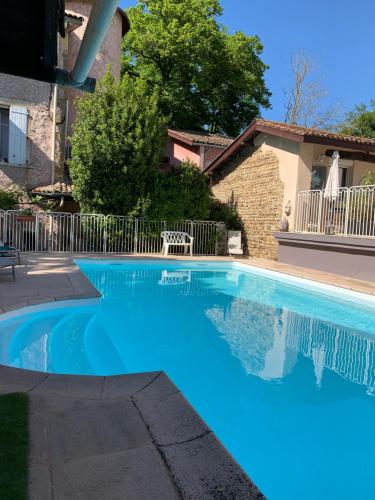 une grande piscine bleue devant une maison dans l'établissement La Gabetière, à Estrablin