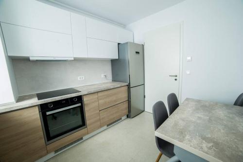 uma cozinha com armários brancos e uma mesa com cadeiras em Kasper Escape em Brasov