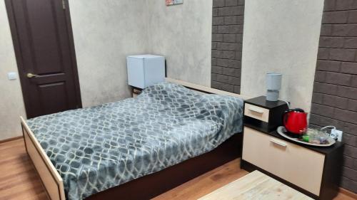 a small bedroom with a bed with a blue comforter at Hotel Europlus in Poltava