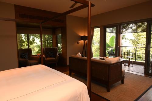 a bedroom with a bed and a balcony at Taj Chia Kutir Resort & Spa Darjeeling in Darjeeling