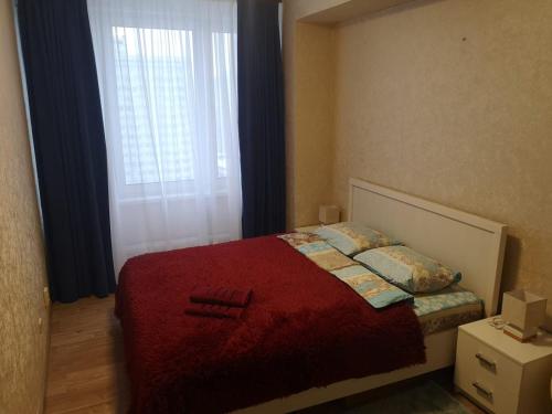 モスクワにあるLakshmi Novy Arbat Panoramaのベッドルーム1室(赤毛布、窓付)
