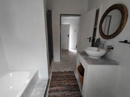 een badkamer met een bad, een wastafel en een spiegel bij 7-on-Burger in Polokwane