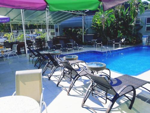 a group of chairs and tables next to a swimming pool at Hotel Serra de Jundiaí in Jundiaí