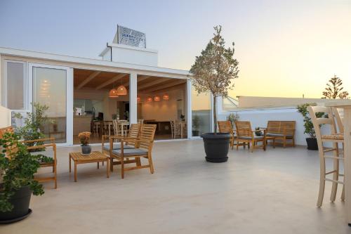 un patio con sedie in legno, tavolo e sedie di Sea Breeze Hotel a Hersonissos