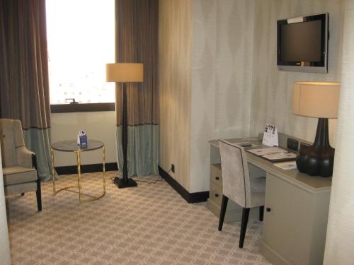 a hotel room with a desk and a table and a television at Hotel Bahía in Santander