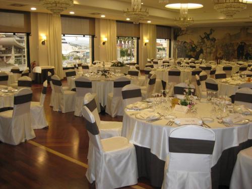 a banquet hall with white tables and chairs at Hotel Bahía in Santander
