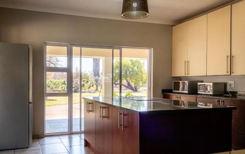 an empty kitchen with a counter and a large window at Tshikwalo Game Lodge in Klipdrift