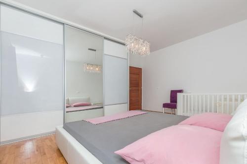 a bedroom with a large bed with pink sheets at Apartment Mario in Strožanac