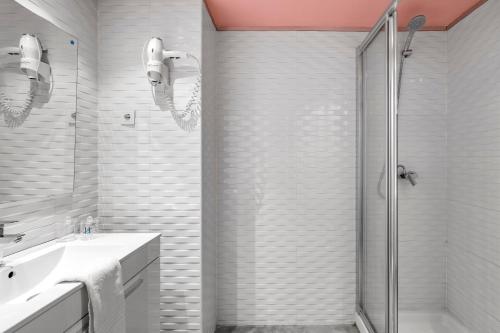 a white bathroom with a shower and a sink at Bob W Chueca in Madrid