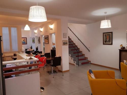 a living room with yellow chairs and a staircase at Buon Hotel Bologna Centro - Affittacamere - Self Check-In in Bologna