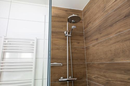 a shower with wooden walls and a glass door at Gasthof Dreiländereck in Schwarzenberg am Bohmerwald