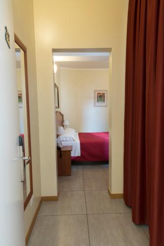 a bedroom with a bed and a red curtain at Buon Hotel Bologna Centro - Affittacamere - Self Check-In in Bologna