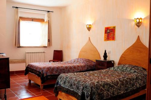 a hotel room with two beds and a window at Casa d'Aldeia in Rio Maior